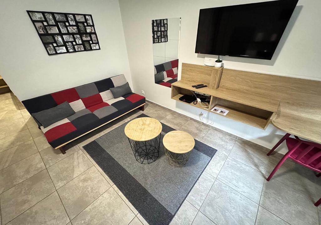 a living room with a couch and a flat screen tv at T2 en centre ville in Cayenne