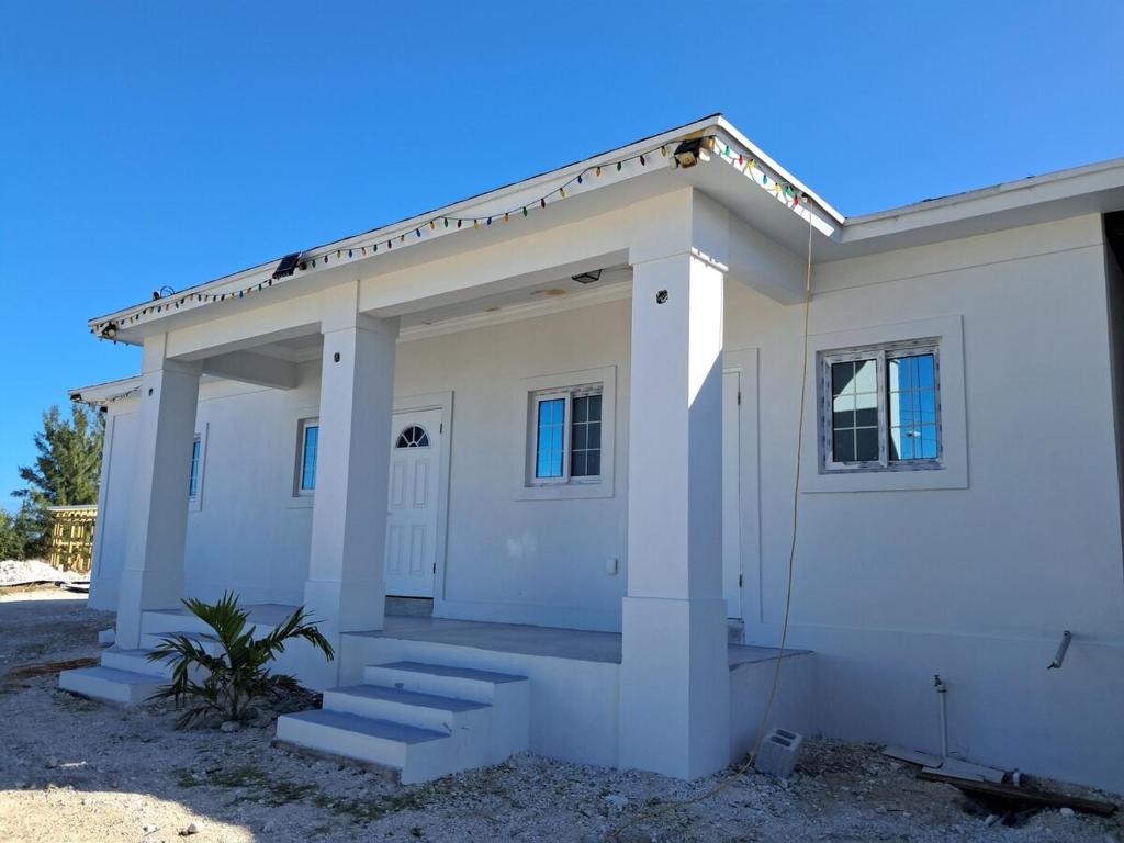 a white house with steps in front of it at Marie view Rentals in Abaco
