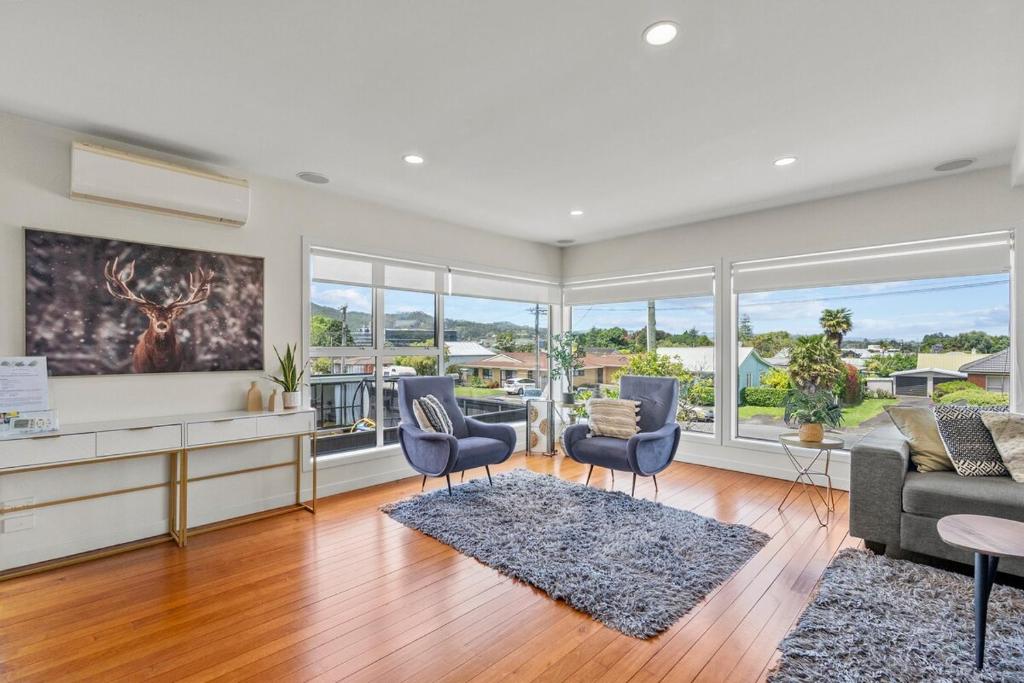 a living room with a couch and chairs at Bliss on Third in Whangarei