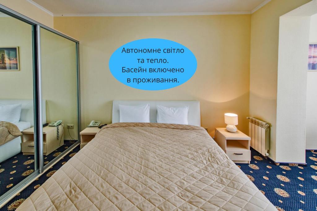 a bedroom with a bed and a sign on the wall at Olympic Sport in Podgortsy