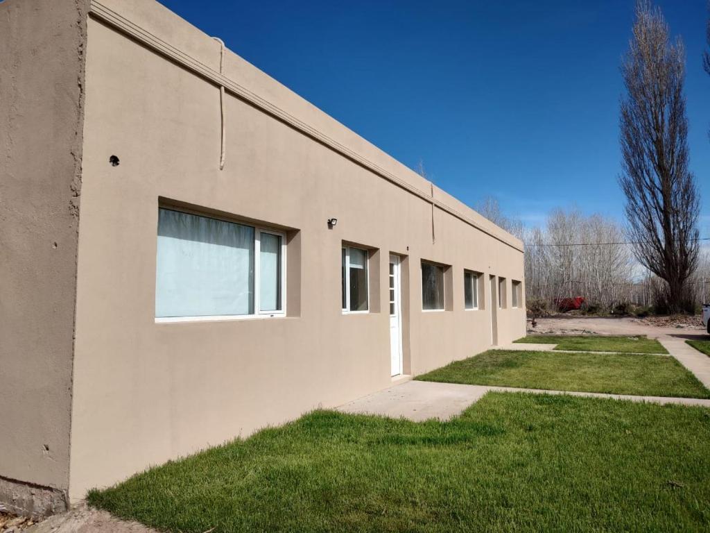 a white building with a window on the side of it at Ancar Añelo in Añelo