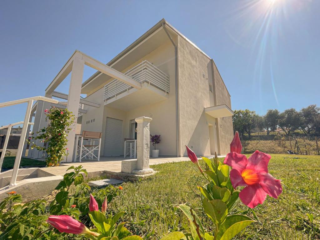 a house with a yard with flowers in front of it at B&B Conero Hermitage in Marcelli