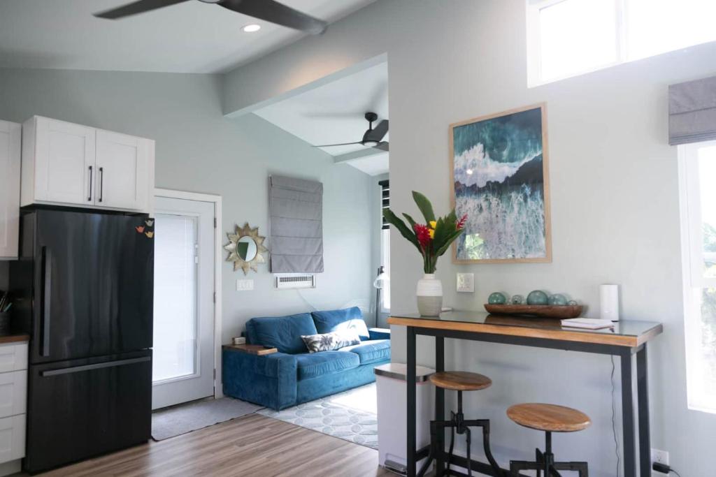 a kitchen and living room with a black refrigerator at North Shore Palms in Mokuleia