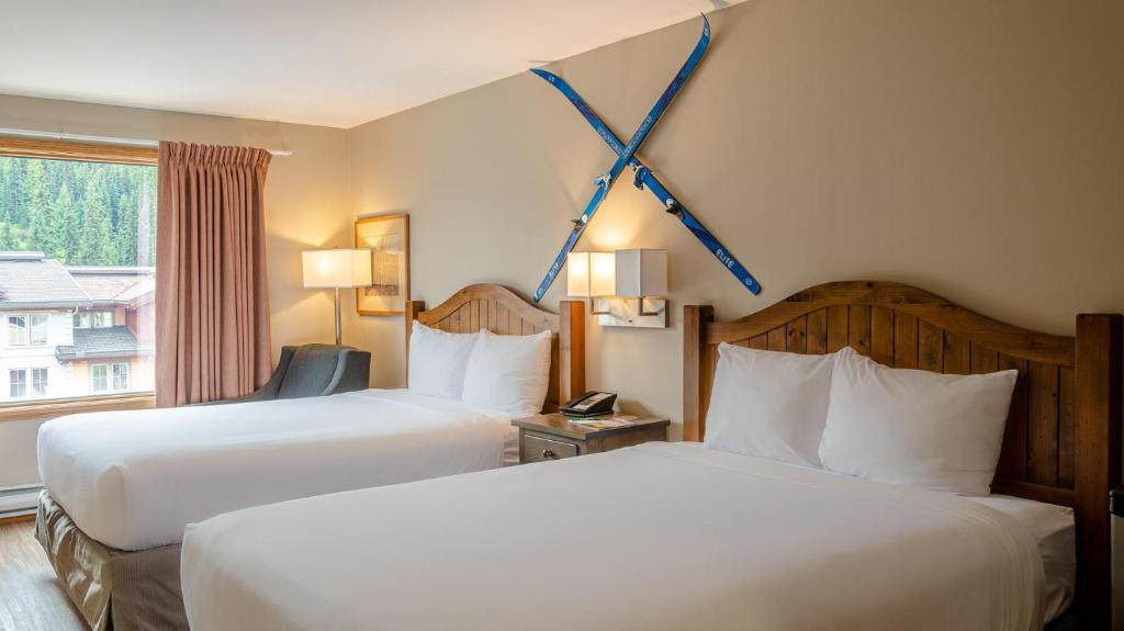 a hotel room with two beds and a window at Cahilty #302 in Sun Peaks