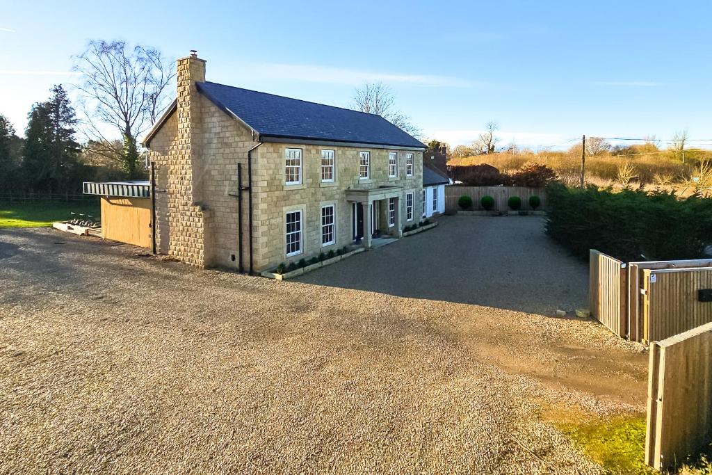 a large brick house with a fence in front of it at Wayside Farm in Staveley