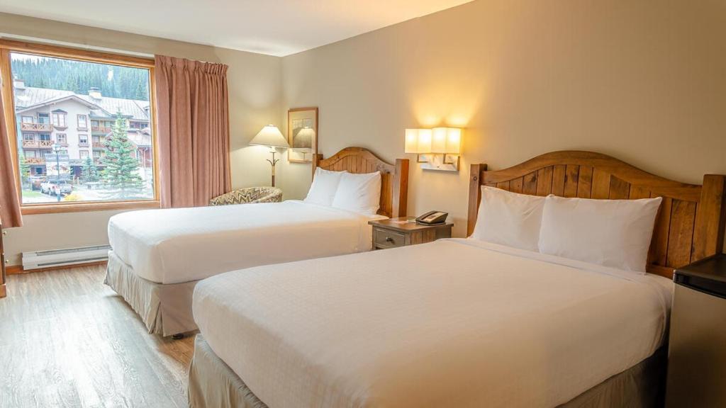 a hotel room with two beds and a window at Cahilty #212 home in Sun Peaks