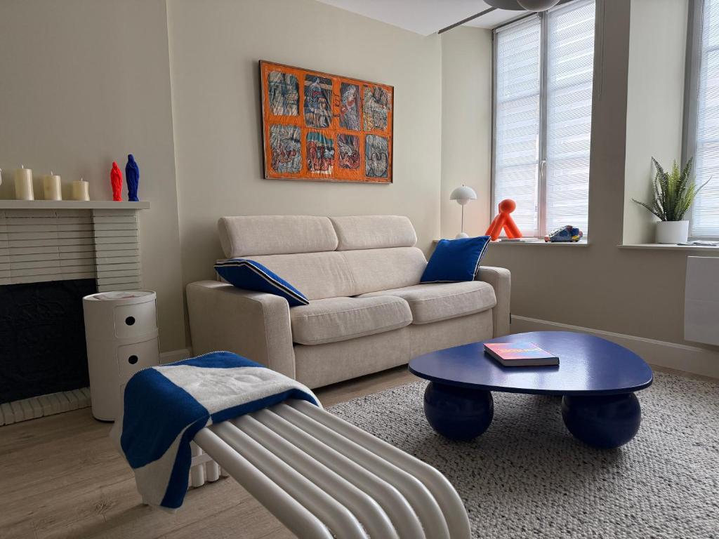 a living room with a couch and a table at Le Pantone in Neufchâteau