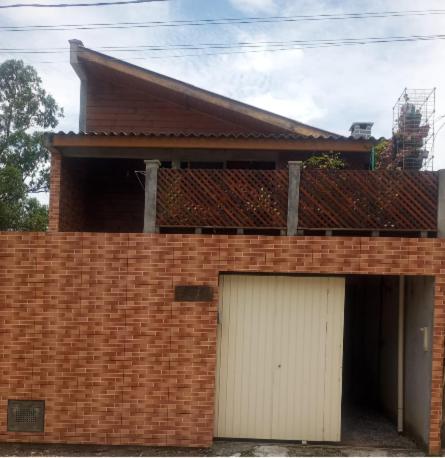 a brick building with a garage with a white door at Casa Flores do Campo in Florianópolis