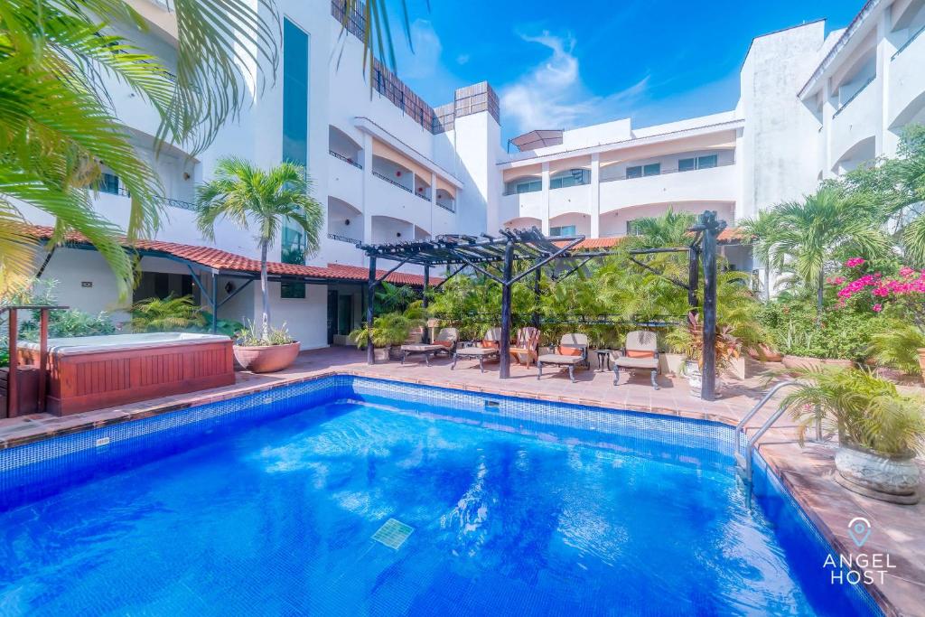 a swimming pool in front of a building at Walk to 5th Ave & Beach - Pools, Balcony & Parking in Playa del Carmen
