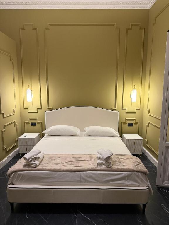a bedroom with a bed with yellow walls and lights at Four Rooms Luxury Suite in Palermo