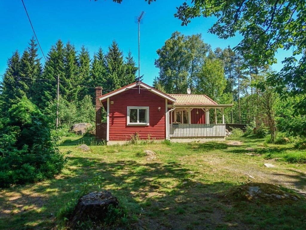 a red house in the middle of a yard at KRO891-Hallaryd-Kalvshult-8 in Hallaryd