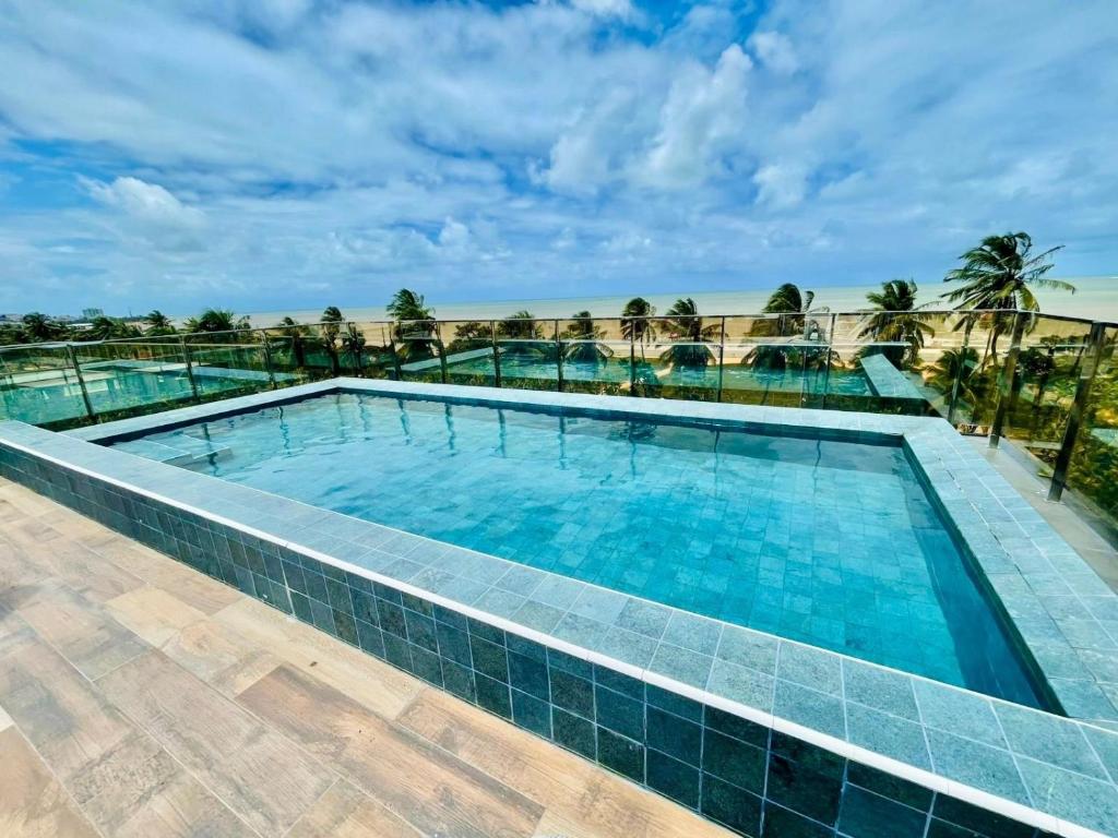 a swimming pool in a resort with blue water at Cabo Branco - Fortune in Tambaú