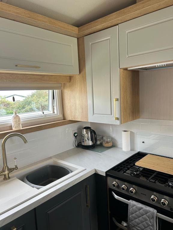 a kitchen with a sink and a stove at Dollys Den in Pagham
