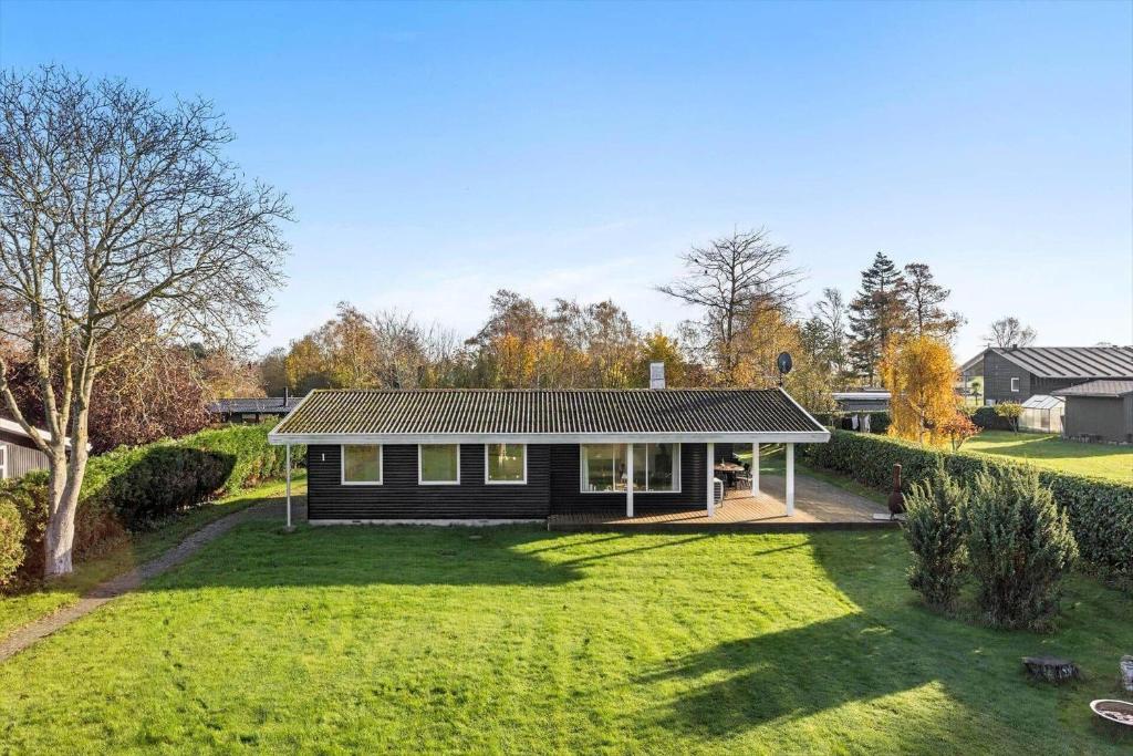 a small black house with a large yard at LL261-Humble-Gyvelvaenget-1 in Spodsbjerg