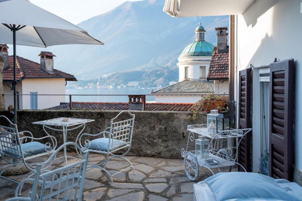 a patio with a table and chairs and a lighthouse at Loving Loppia - Glicine in Bellagio
