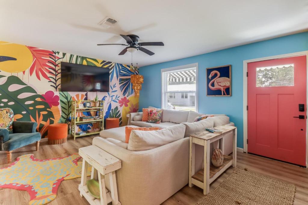 a living room with a couch and a red door at The Tropical Cottage in Long Beach