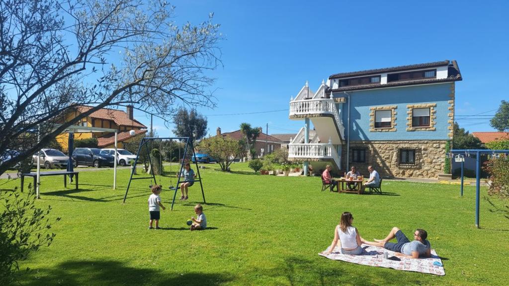 a group of people sitting on the grass in a park at El BurbyI in Somo