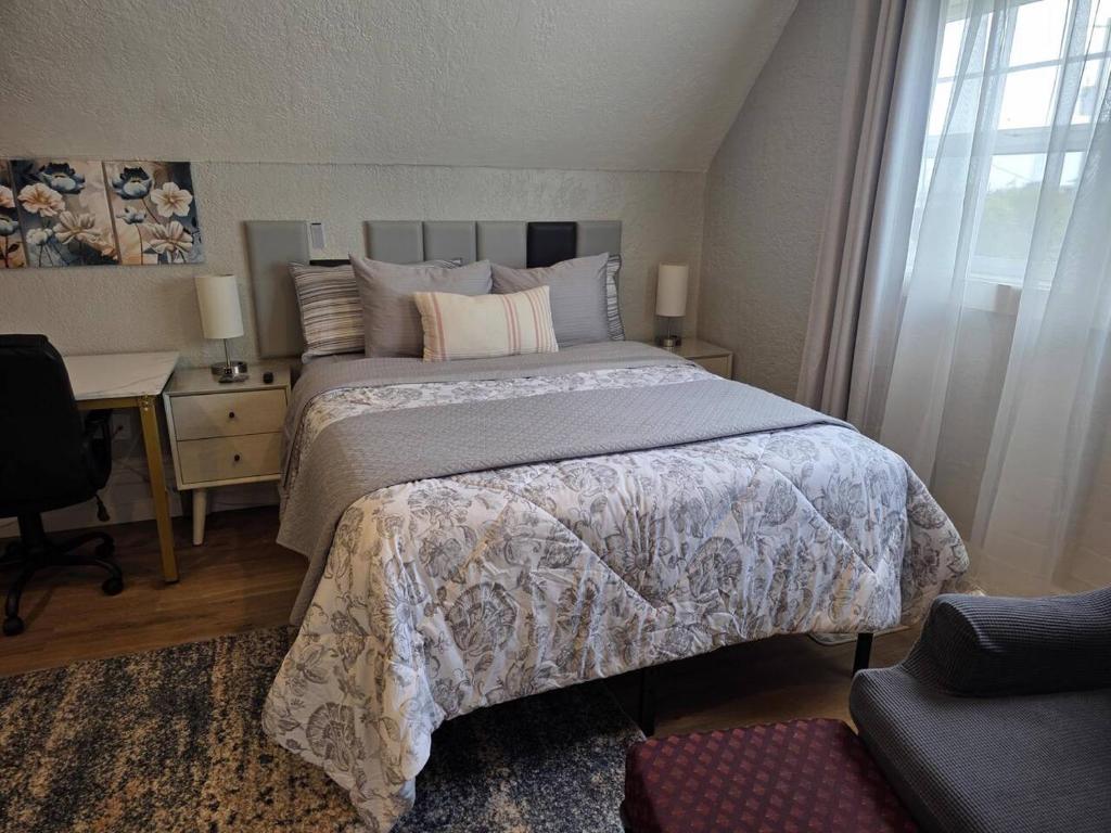 a bedroom with a large bed with a desk and a window at Modern Victorian by Beach and Forest Unit C in Crescent City