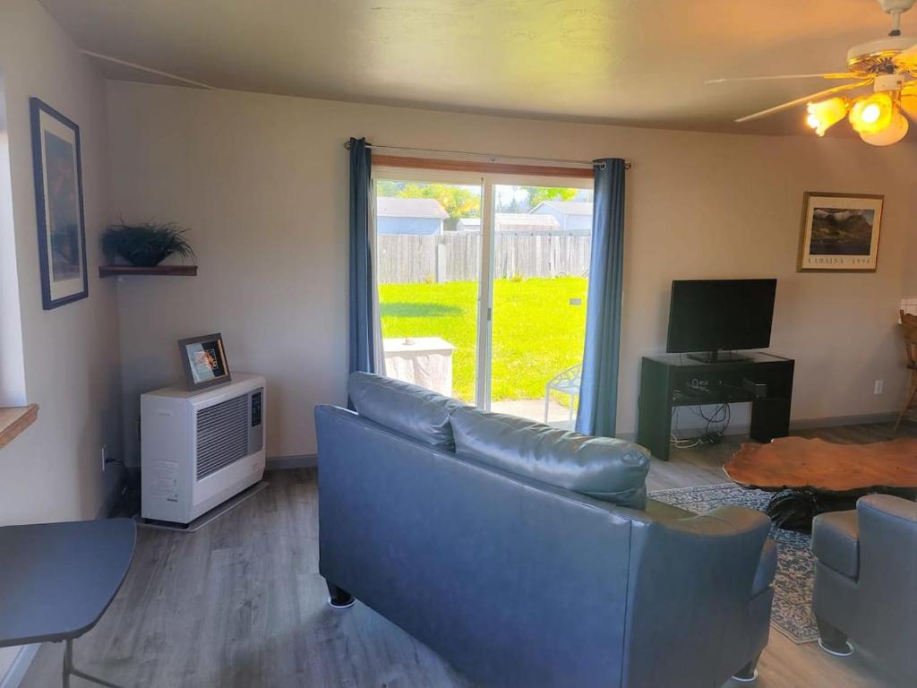 a living room with a blue couch and a television at The Hofer Beach Retreat in Crescent City