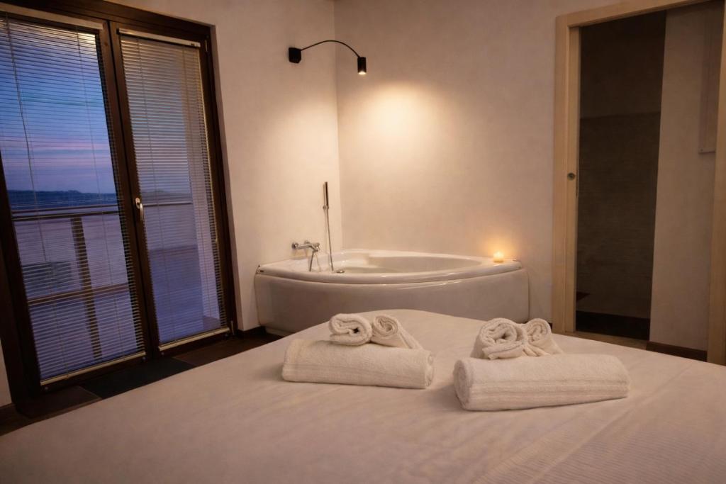 a bathroom with a tub and towels on a bed at IL CAMBUSIERE nature relais in Ortona