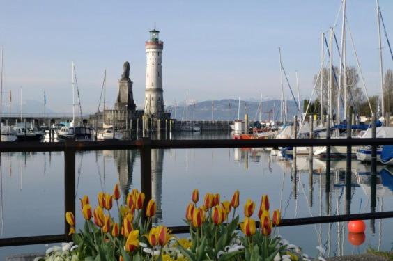 a harbor with a lighthouse and flowers in the water at Ferienwohnung über den Dächern in Lindau