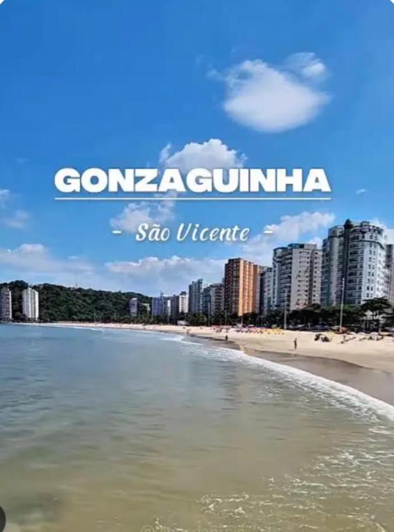 a view of a beach with buildings in the background at AP FRENTE MAR Compacto, Completo e Confortável in São Vicente