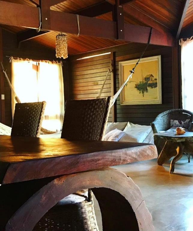 a dining room with a wooden table and chairs at Casa Da MAELA in Corumbau