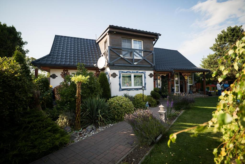 a house with a black roof and a walkway at Drevenička Modruška in Malý Čepčín