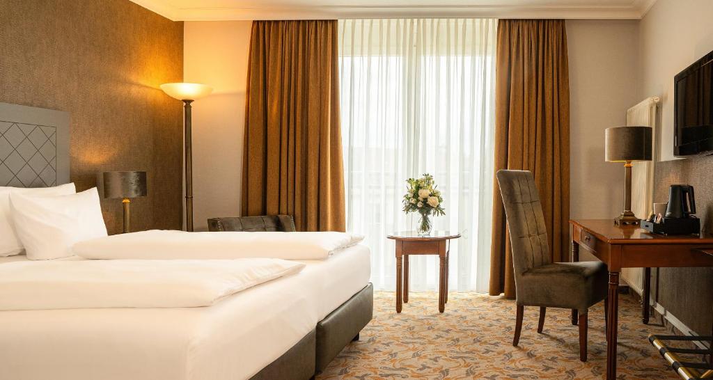 a hotel room with two beds and a desk at Victor's Residenz-Hotel Berlin Mitte in Berlin