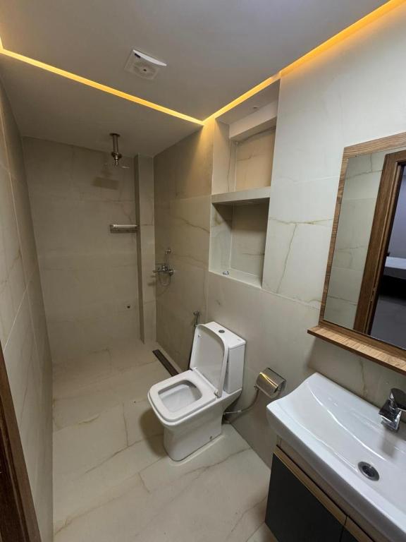 a bathroom with a toilet and a sink and a mirror at Hotel kairouan in Fez