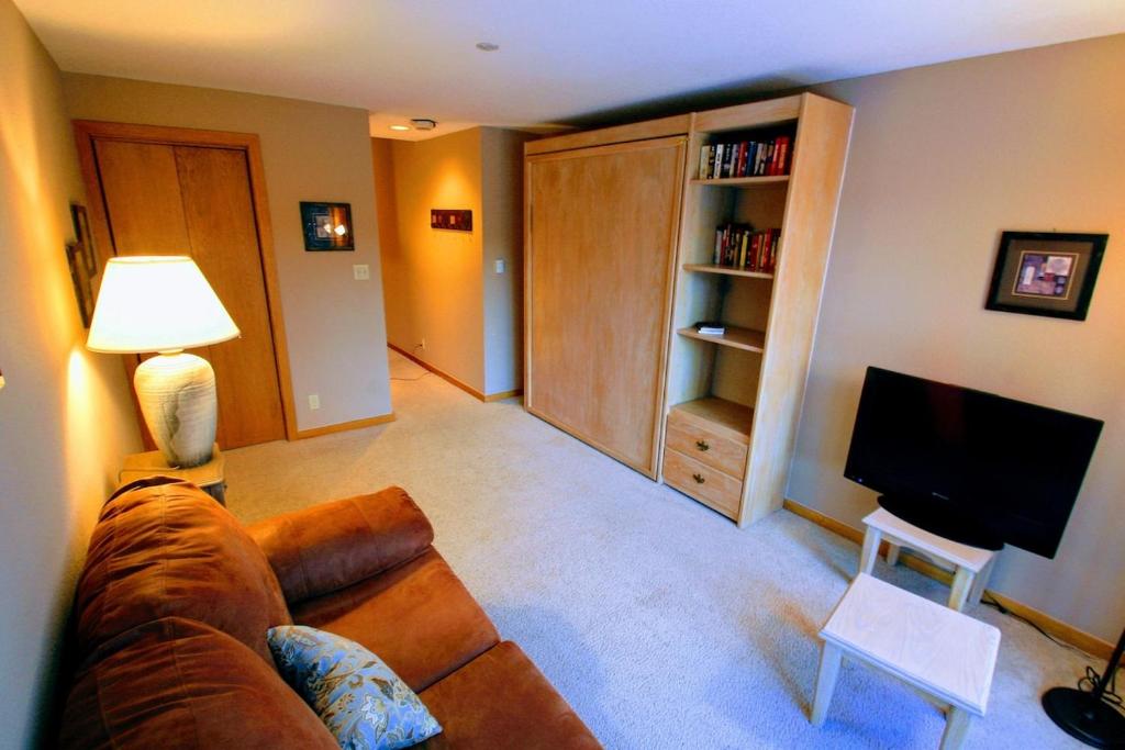 a living room with a couch and a television at Mountain Adventure Basecamp + Hot Tubs in Winter Park
