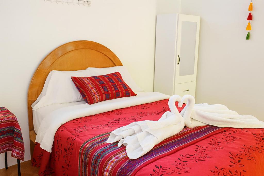 a bed with two swans sitting on top of it at HOSTAL ACUARIUS PUNO in Puno