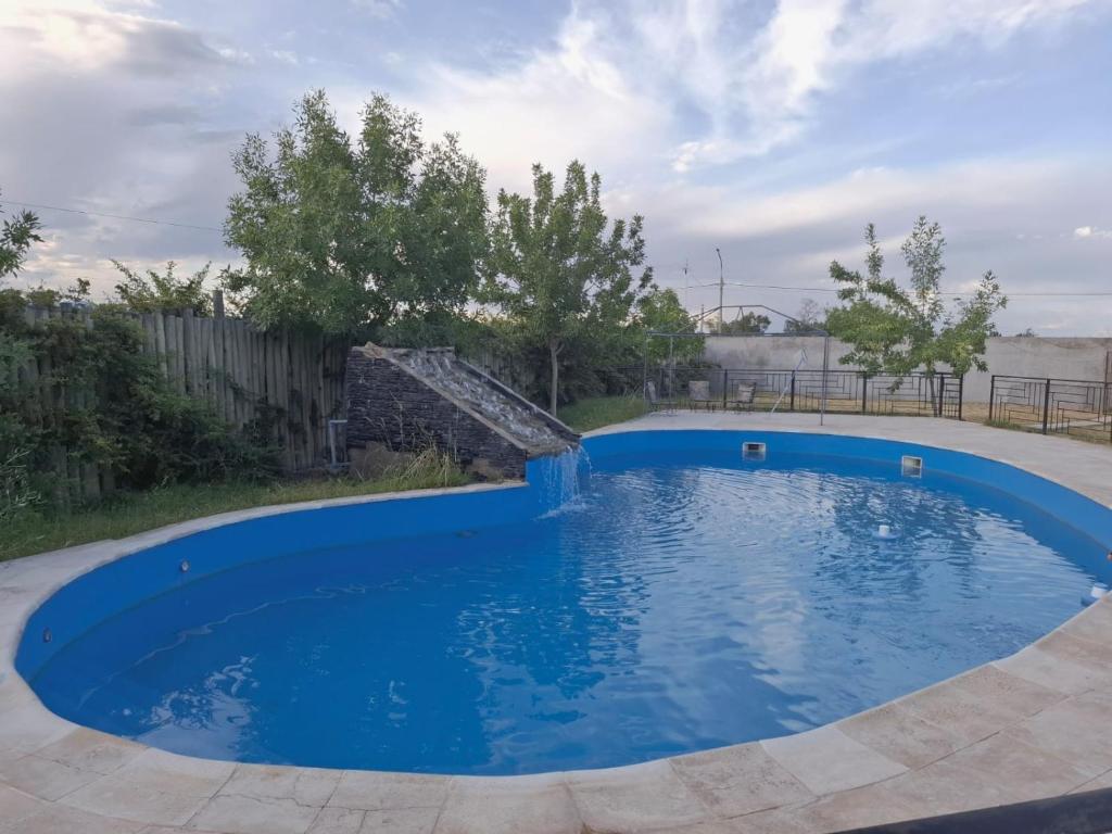 a large blue pool with a waterfall in a yard at Oasis Pueyrredón in Rodeo del Medio