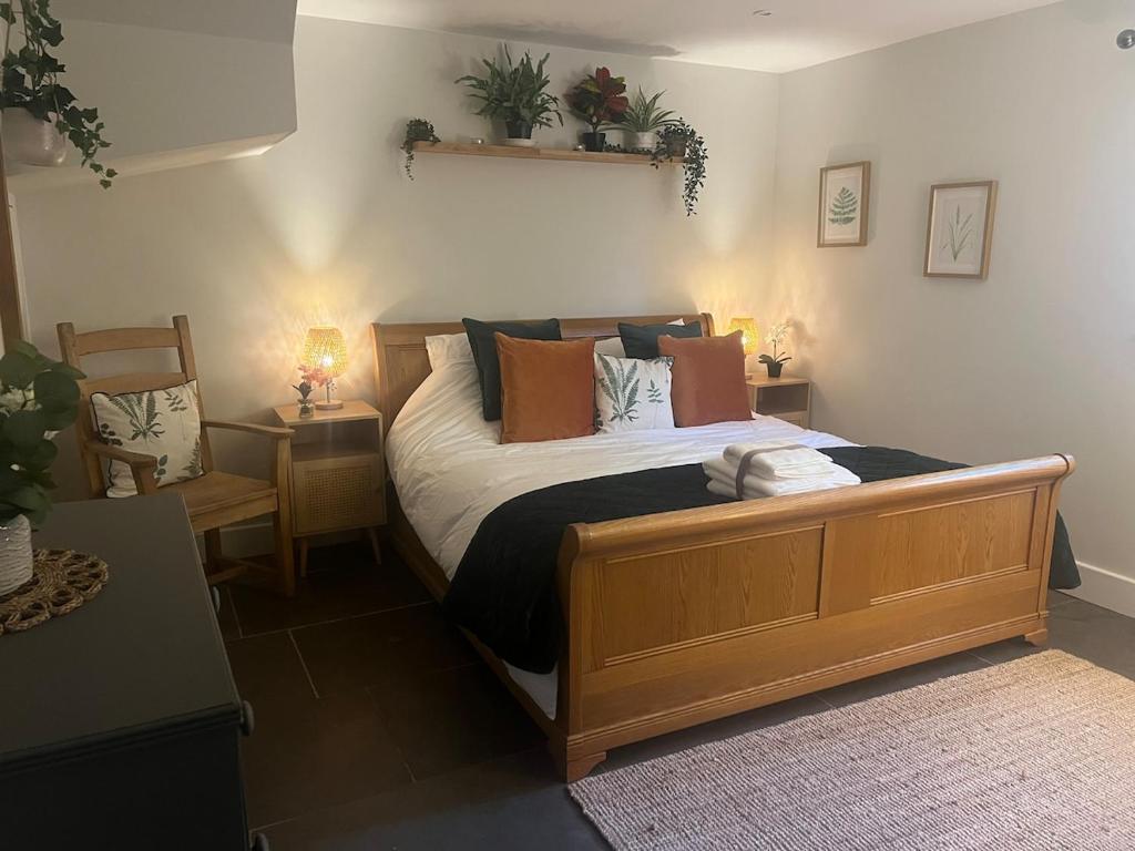 a bedroom with a large wooden bed with pillows at Chiltern Studio in Wendover