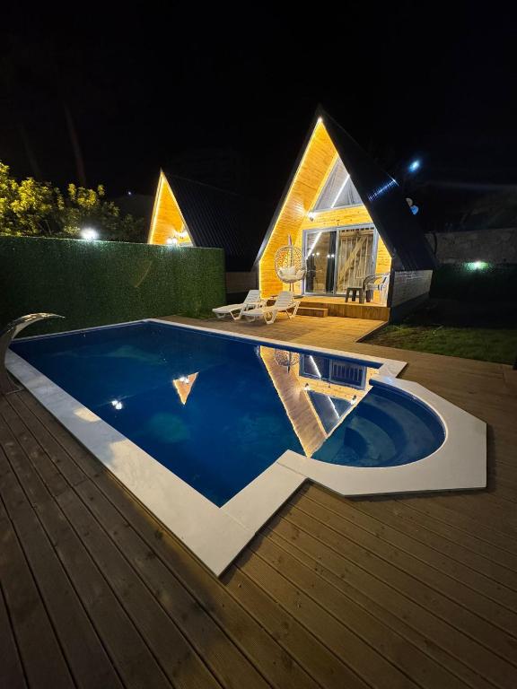 a swimming pool in front of a house at night at Evergreen Lodge-3 in Çakırlar