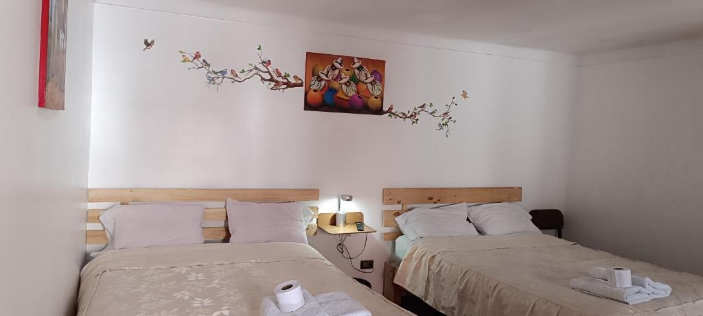 a bedroom with two beds and a painting on the wall at Anais y Nicolas Cusco in Cusco