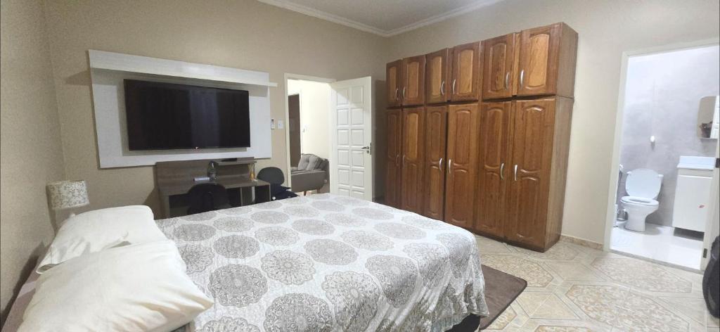 a bedroom with a bed and a flat screen tv at Base Luz na Floresta in Manaus