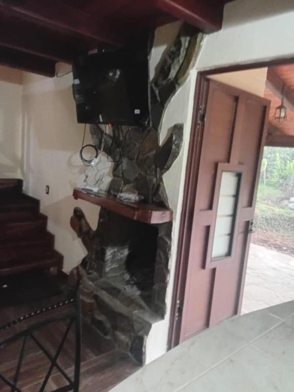 a room with a door and a stone fireplace at Cabaña lagunita in Sabinas
