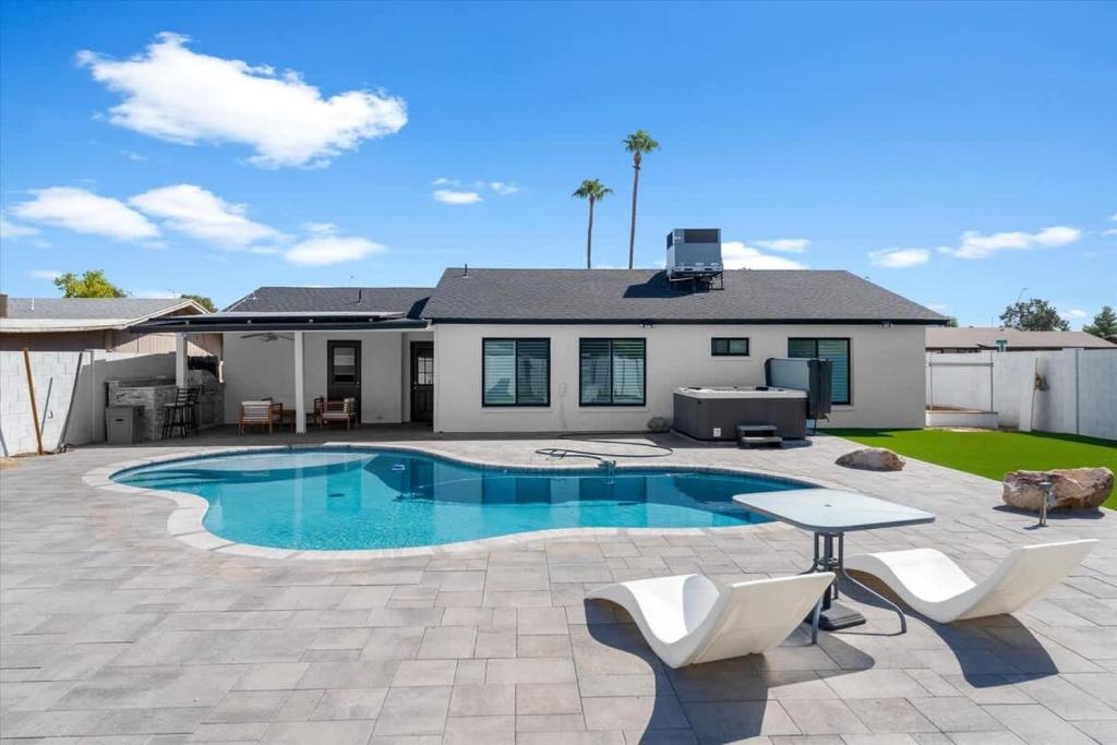 a backyard with a swimming pool and a house at Rock and Glam Paradise in Mesa