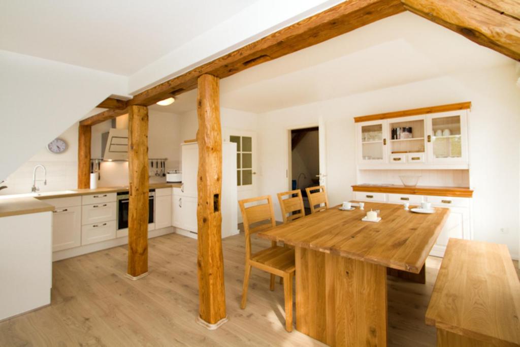 a kitchen and dining room with a wooden table and chairs at Kapitänsdeck in Wustrow