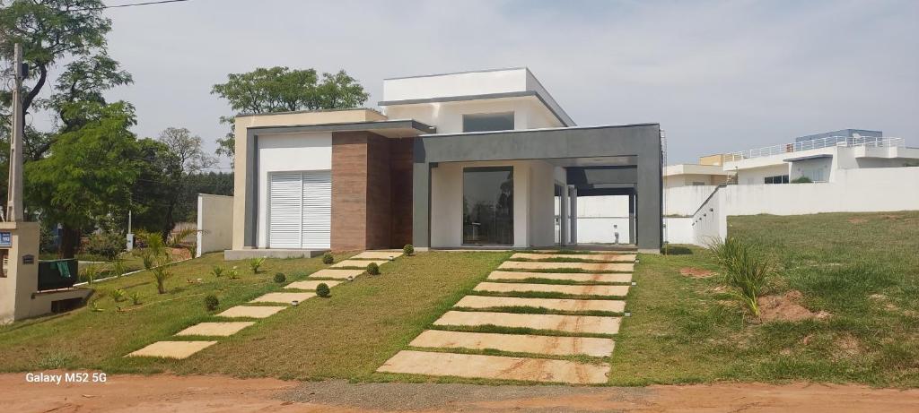 a house with a lawn in front of it at Casa Condomínio Ninho Verde II in Pardinho