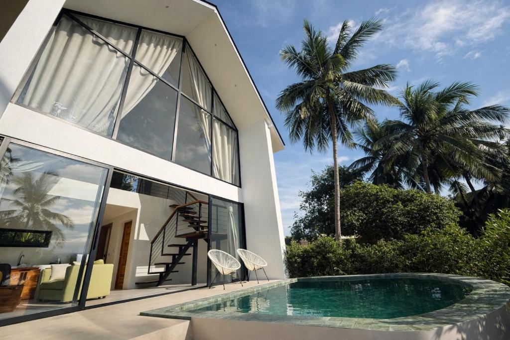 a house with a swimming pool in front of it at Sumba Luxury Pool Cottages in Ko Phangan