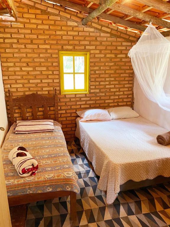 a bedroom with two beds in a brick wall at Canto da Águia in Ouro Preto