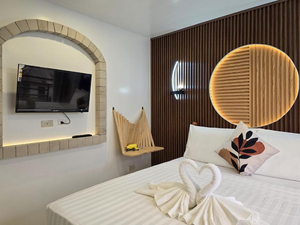 a bedroom with a bed and a tv on a wall at SilverLeaf in El Nido