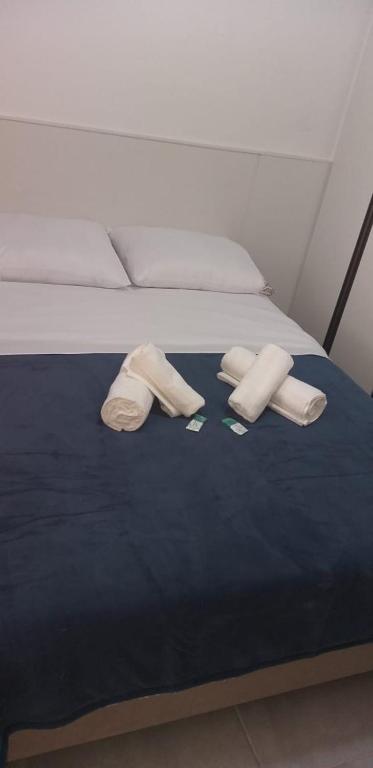 a bed with two pairs of underwear and slippers on it at Apartamento Studio in Barbacena