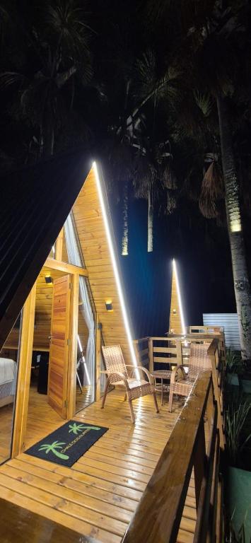 a wooden deck with two chairs and a table at chalé dos Buritis 01 in Chapada dos Guimarães