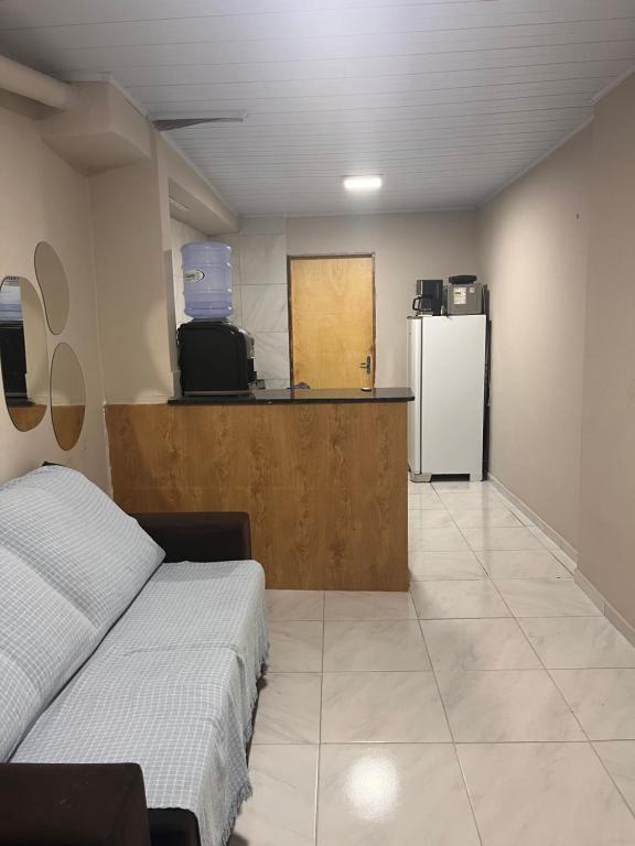 a room with a bed and a counter with a refrigerator at Kit net da flor in Fortim