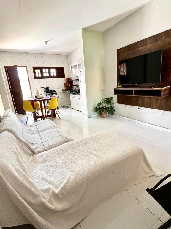 a bedroom with a large bed and a kitchen at Casa Flor e Ser Rua Onezinda da Costa Barros ,80 in Parnaíba