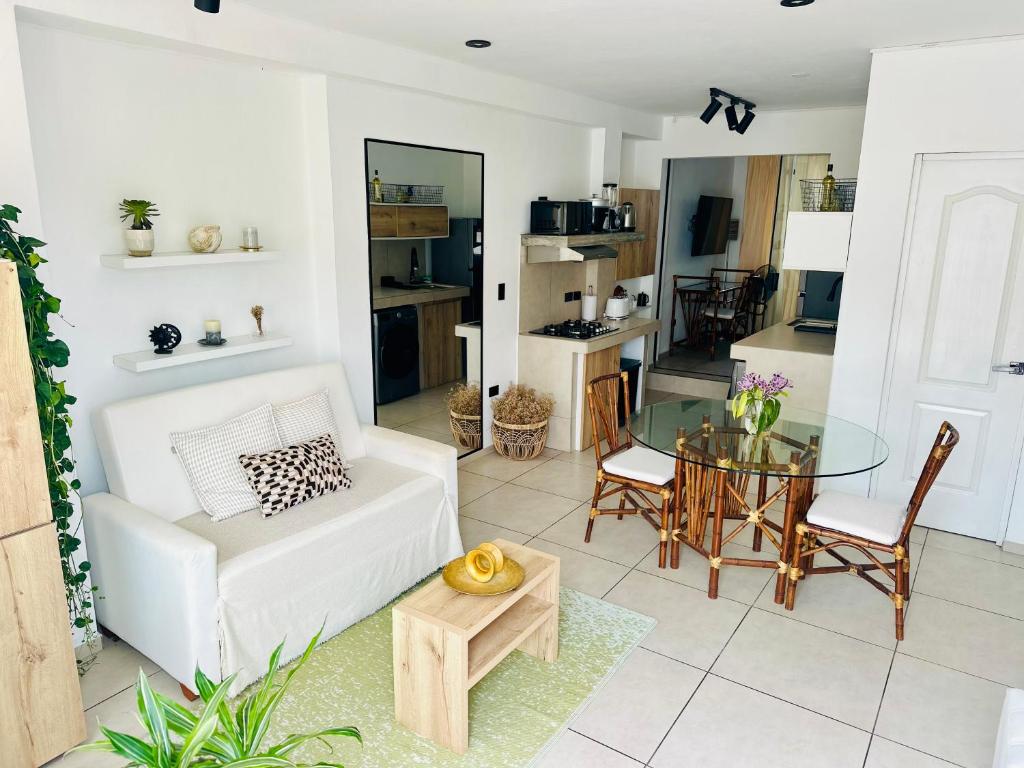 a living room with a white couch and a glass table at Apartamentos Boho in Punta Hermosa