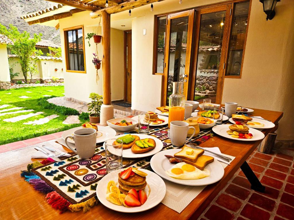 a wooden table with plates of food on it at Hotel and Country House Valle Sagrado de los Incas in Huaran